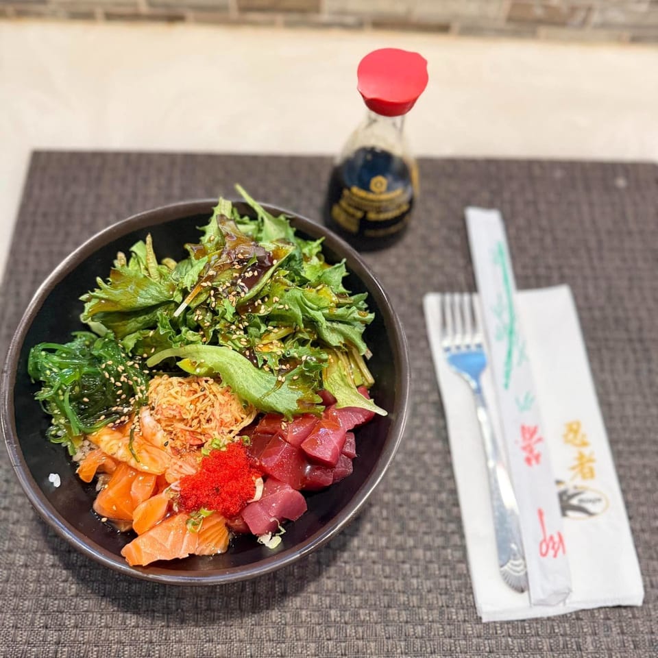 A colorful Ninja Japanese Restaurant poke bowl with salmon, tuna, roe, seaweed, and greens.