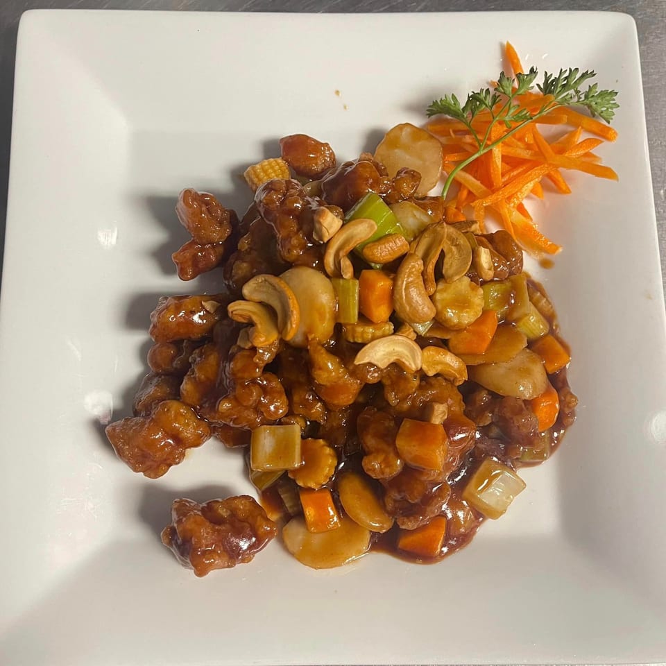 Ninja Japanese Restaurant's cashew chicken with vegetables and shredded carrots on a white plate.